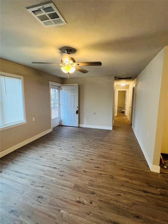 empty room with ceiling fan and dark wood-type flooring