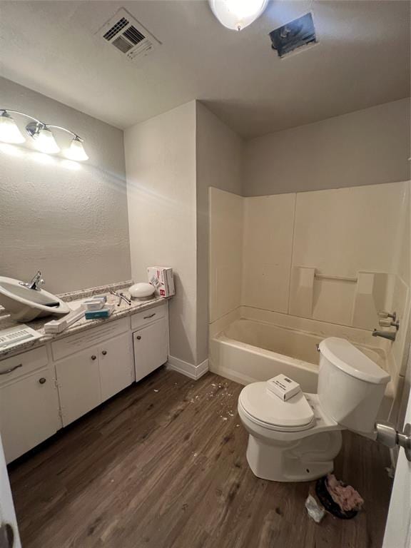 full bathroom with shower / tub combination, vanity, wood-type flooring, and toilet