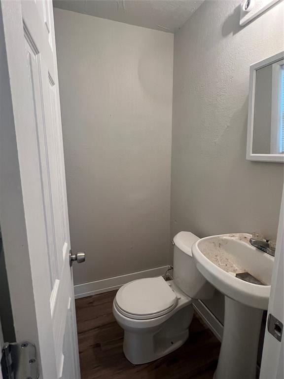 bathroom featuring hardwood / wood-style floors and toilet