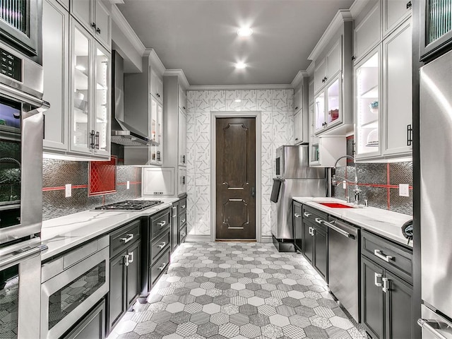 kitchen with backsplash, light stone counters, stainless steel appliances, sink, and white cabinets