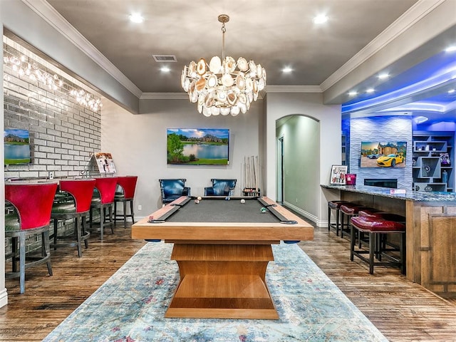 rec room featuring dark hardwood / wood-style flooring, an inviting chandelier, ornamental molding, and billiards