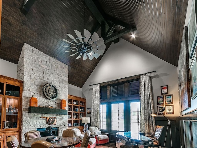 dining space with ceiling fan, high vaulted ceiling, beamed ceiling, a fireplace, and wood ceiling