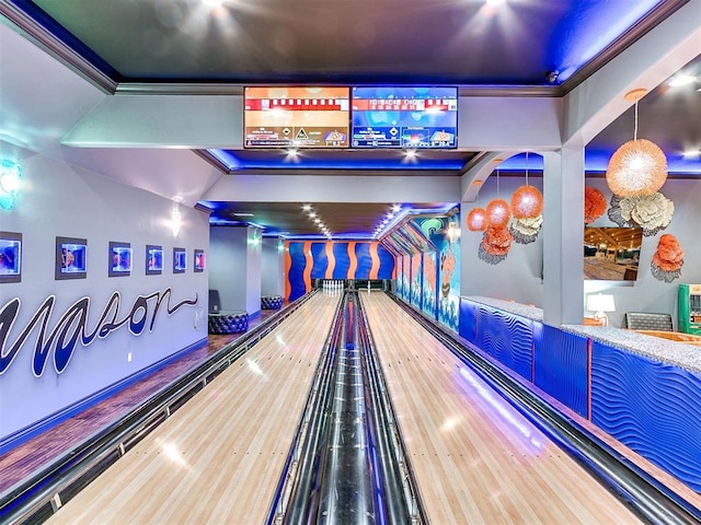 game room with a bowling alley, hardwood / wood-style flooring, and ornamental molding