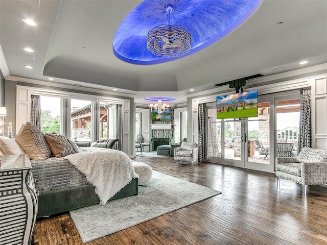 bedroom with access to outside, crown molding, a tray ceiling, a notable chandelier, and wood-type flooring