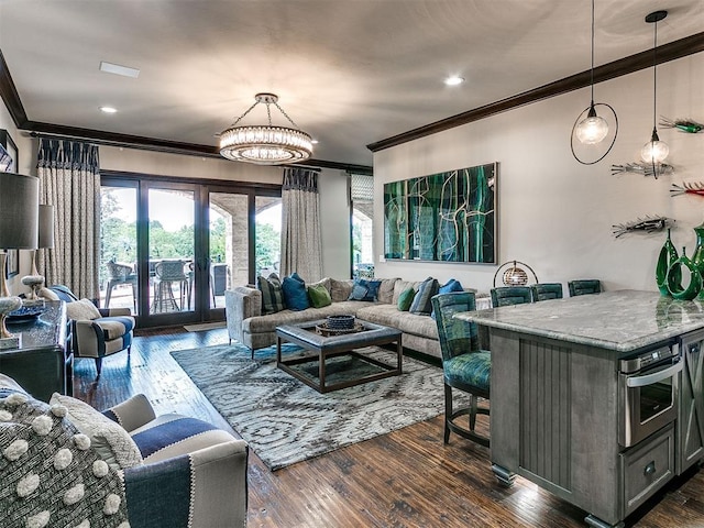 living room with dark hardwood / wood-style floors, ornamental molding, and a chandelier