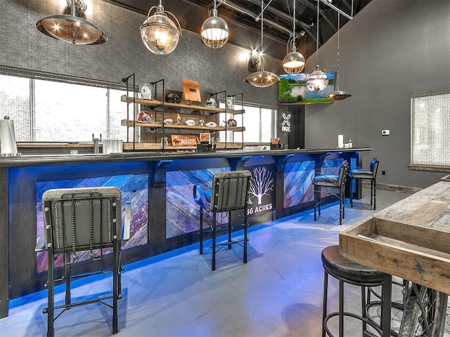 bar featuring concrete flooring and a healthy amount of sunlight