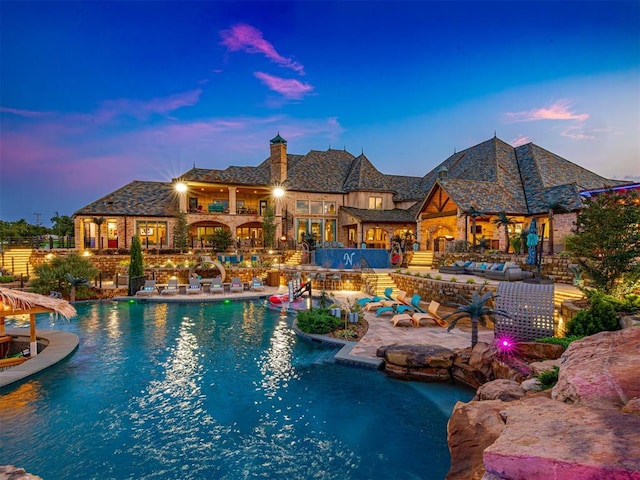 pool at dusk with a patio area