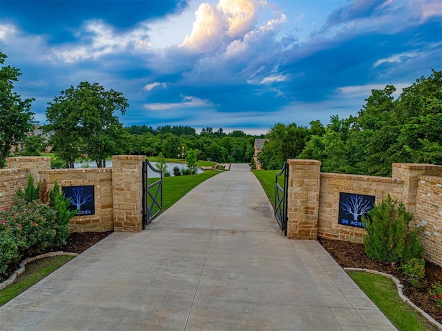 view of gate with a yard and a water view