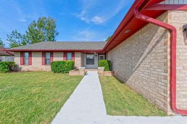 view of exterior entry featuring a yard