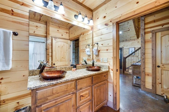 bathroom with wood walls, vanity, concrete floors, and wooden ceiling