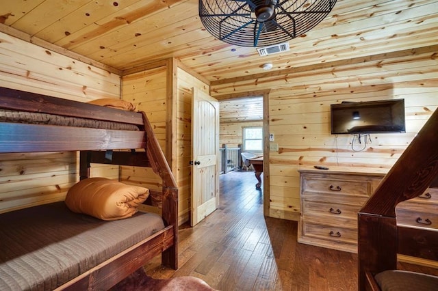 bedroom with wood walls, hardwood / wood-style floors, and wood ceiling