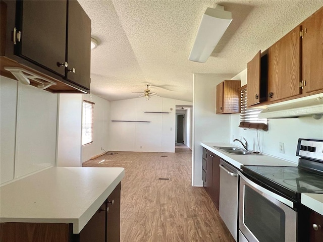 kitchen with lofted ceiling, light hardwood / wood-style flooring, ceiling fan, a textured ceiling, and appliances with stainless steel finishes