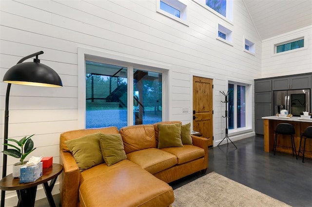 living room with wood walls and high vaulted ceiling