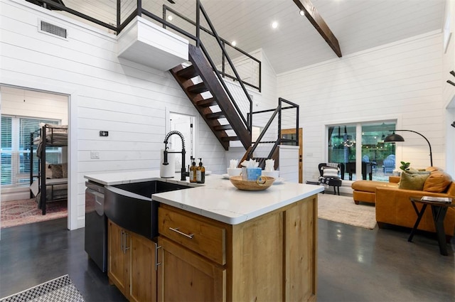 kitchen featuring beam ceiling, a center island with sink, and high vaulted ceiling