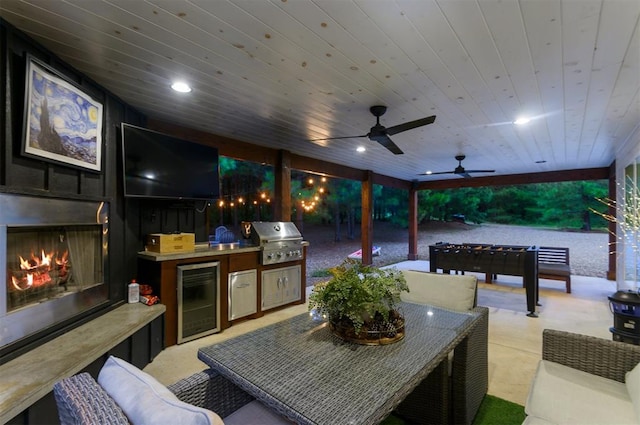 view of patio / terrace featuring an outdoor hangout area, area for grilling, ceiling fan, exterior kitchen, and wine cooler