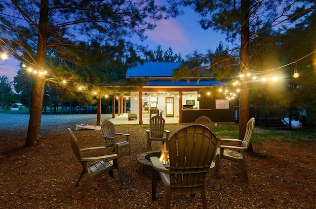 back house at dusk with a patio and an outdoor fire pit