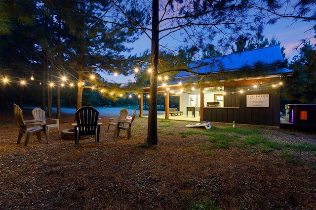 yard at dusk featuring a patio area and a water view