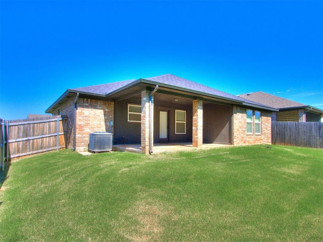 back of house featuring a patio, a yard, and central AC