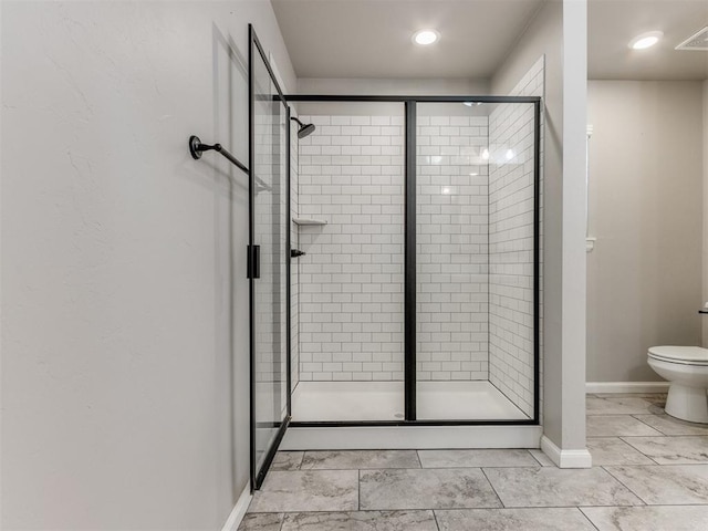 bathroom with an enclosed shower and toilet