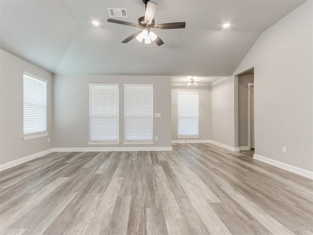 unfurnished room featuring ceiling fan with notable chandelier, light hardwood / wood-style flooring, and vaulted ceiling