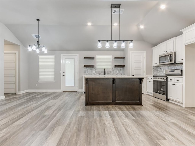 kitchen featuring lofted ceiling, an inviting chandelier, light hardwood / wood-style flooring, decorative light fixtures, and stainless steel appliances