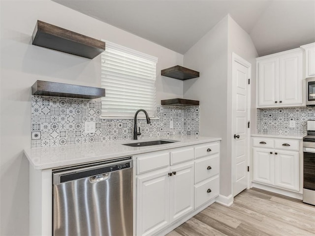 kitchen with sink, light hardwood / wood-style flooring, decorative backsplash, white cabinets, and appliances with stainless steel finishes