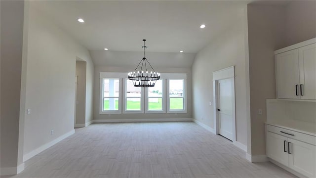 unfurnished dining area featuring light hardwood / wood-style floors, an inviting chandelier, and vaulted ceiling