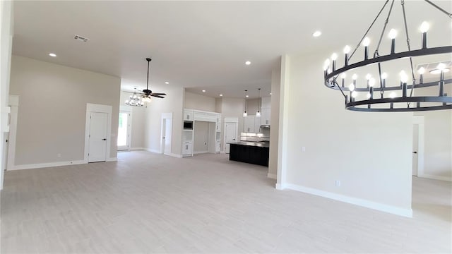 unfurnished living room featuring ceiling fan and light hardwood / wood-style floors