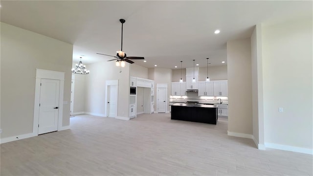 kitchen featuring ceiling fan with notable chandelier, a center island, light hardwood / wood-style flooring, and white cabinetry