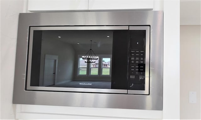 interior details with a notable chandelier and stainless steel microwave