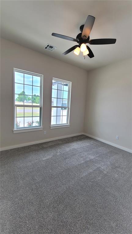 carpeted empty room featuring ceiling fan