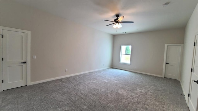 carpeted spare room featuring ceiling fan