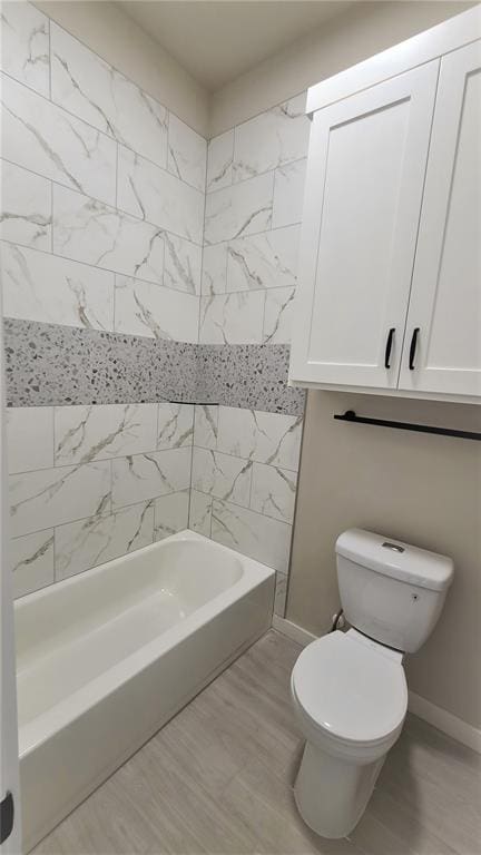 bathroom with tiled shower / bath and toilet