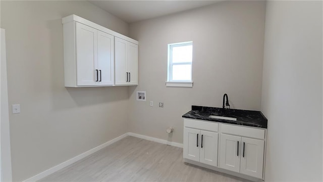 clothes washing area with washer hookup, hookup for a gas dryer, cabinets, and light hardwood / wood-style flooring