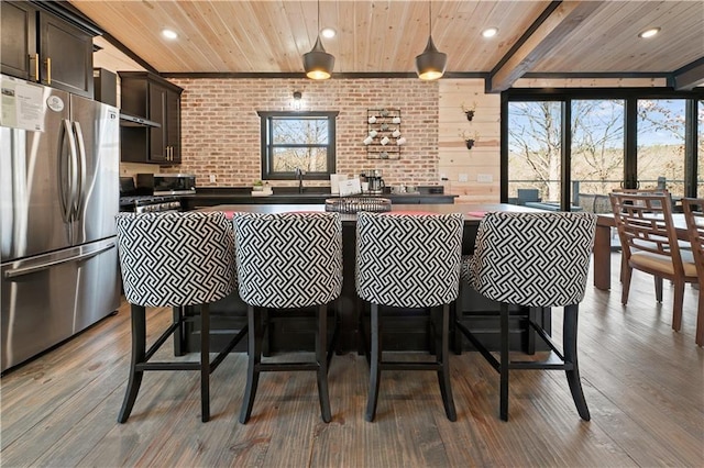 kitchen with pendant lighting, stainless steel fridge, a healthy amount of sunlight, and hardwood / wood-style flooring