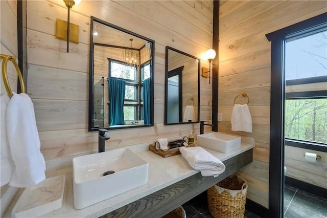 bathroom with a notable chandelier, wood walls, and vanity