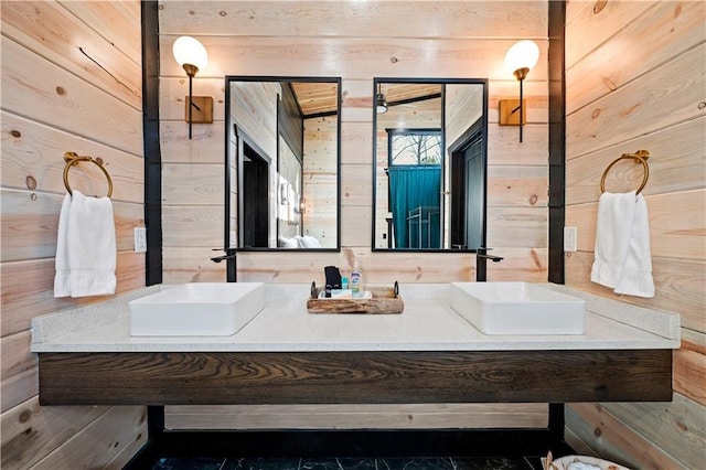 bathroom featuring vanity and wooden walls