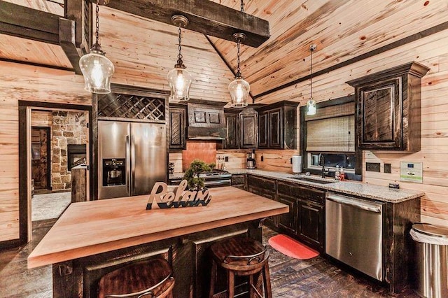 kitchen featuring sink, lofted ceiling with beams, dark brown cabinets, a kitchen island, and appliances with stainless steel finishes