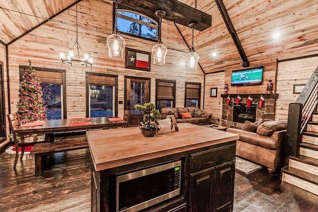 bar featuring beamed ceiling, stainless steel microwave, and high vaulted ceiling