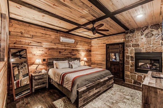 21 Mayflower Cir, Broken Bow, OK 74728 - bedroom featuring wood ceiling with exposed beams, wood walls, an AC wall unit, hardwood / wood-style flooring, and a stone fireplace