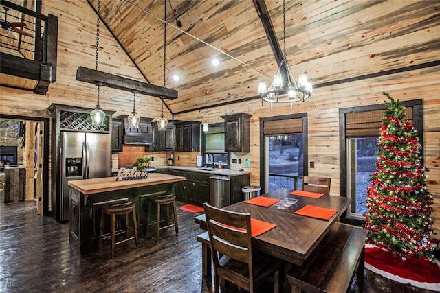 dining space with dark hardwood / wood-style flooring, wooden walls, sink, high vaulted ceiling, and wooden ceiling