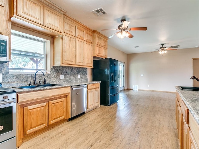 kitchen featuring ceiling fan, sink, stainless steel appliances, tasteful backsplash, and light hardwood / wood-style flooring