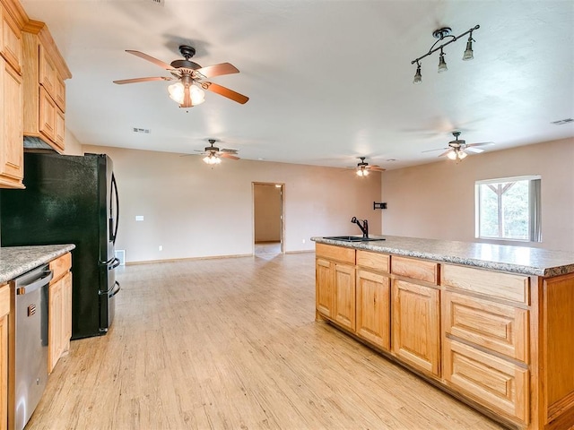 kitchen with light brown cabinets, a kitchen island with sink, sink, light hardwood / wood-style flooring, and appliances with stainless steel finishes