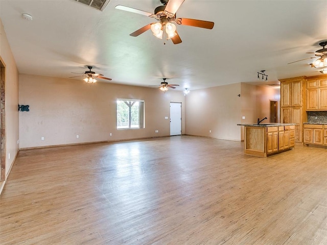 unfurnished living room featuring light wood-type flooring and sink