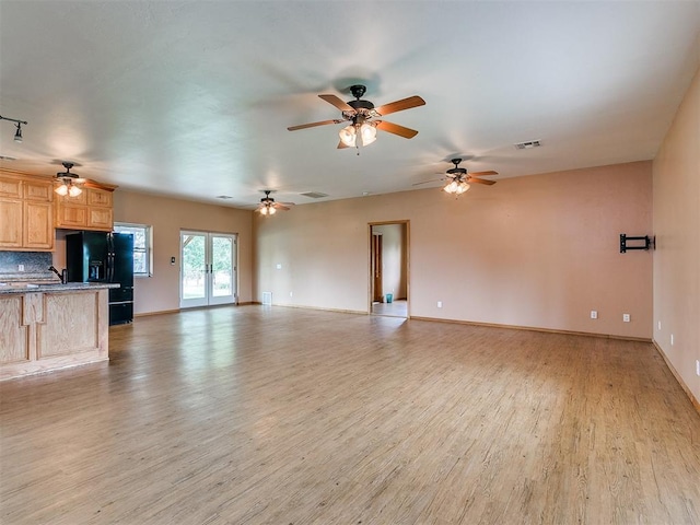 unfurnished living room with light hardwood / wood-style floors and french doors