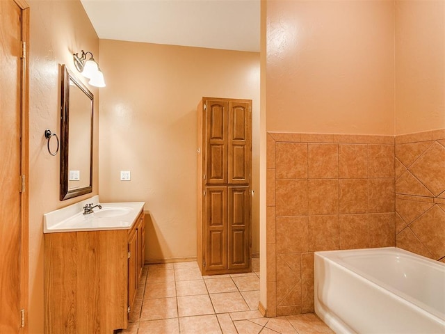 bathroom featuring tile patterned flooring, a bathtub, tile walls, and vanity