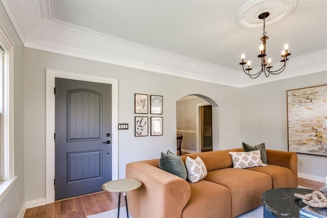 living room featuring hardwood / wood-style floors, ornamental molding, and a notable chandelier