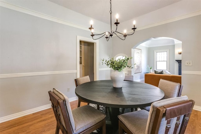 dining room with a chandelier, hardwood / wood-style flooring, and crown molding