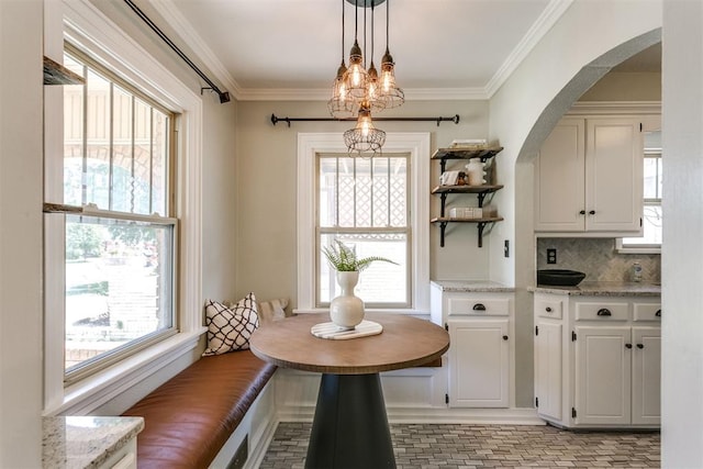 dining space with a wealth of natural light and ornamental molding