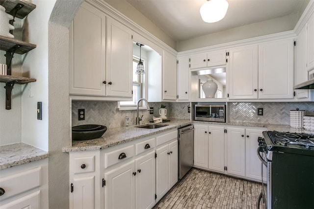 kitchen with appliances with stainless steel finishes, white cabinetry, and sink